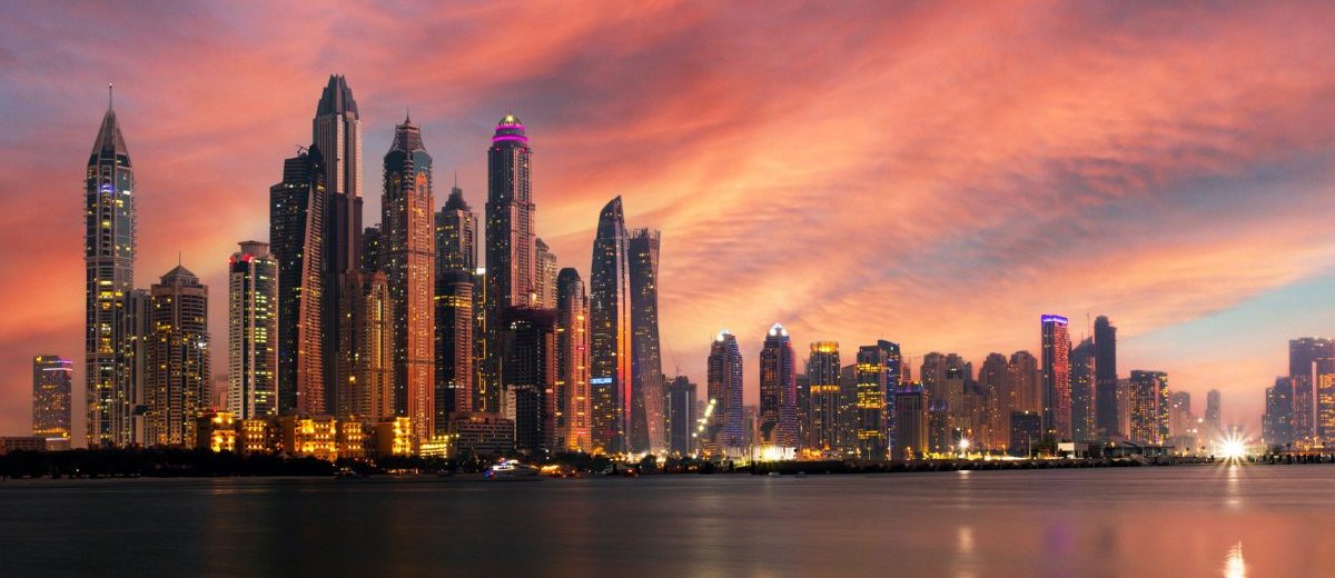 Dubai skyline at sunset over the water.