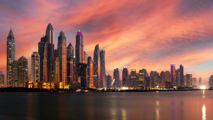 Dubai skyline at sunset over the water.