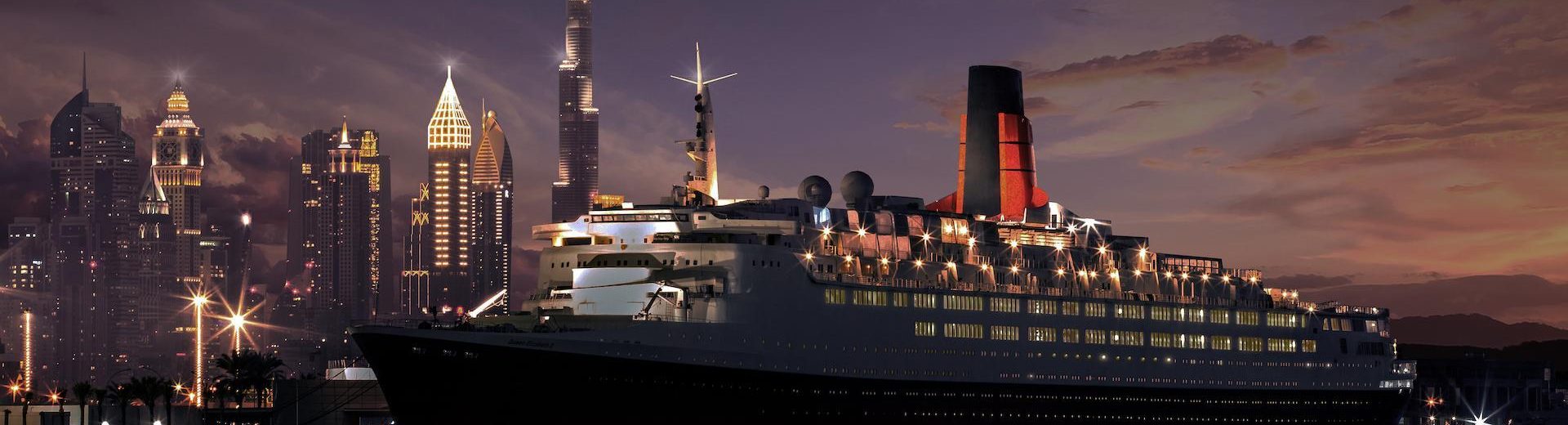 Cruise ship docked with city skyline at night.