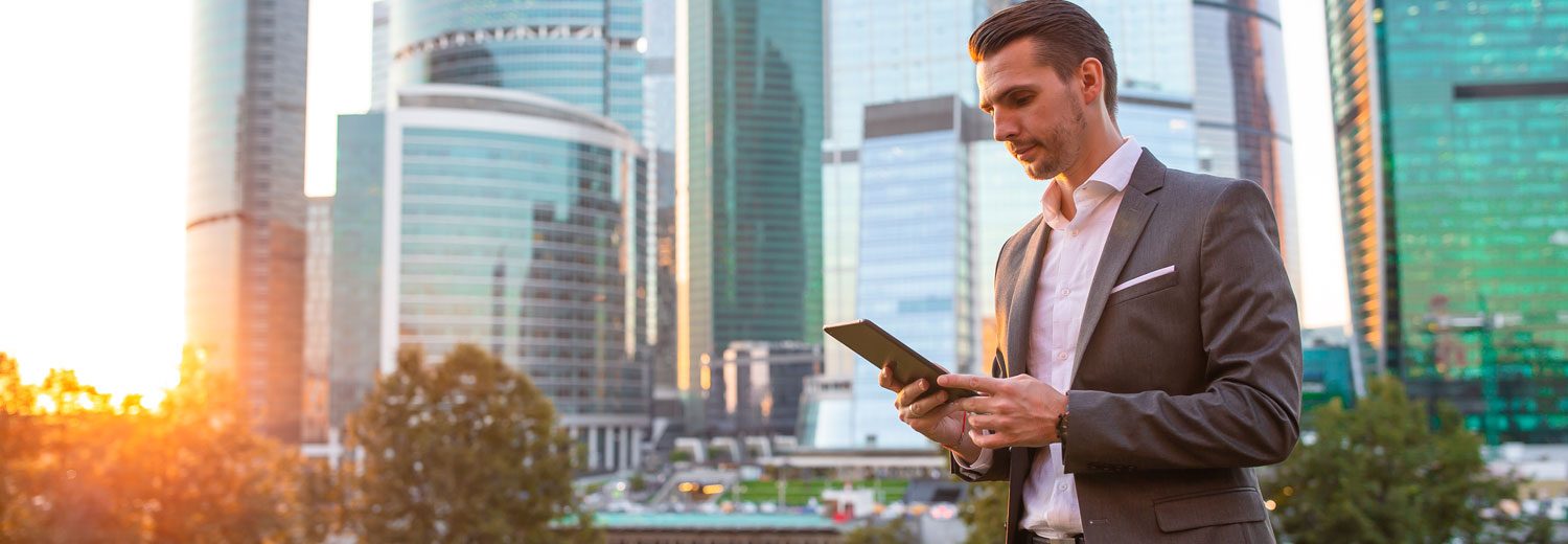 Businessman using tablet with skyscrapers in background