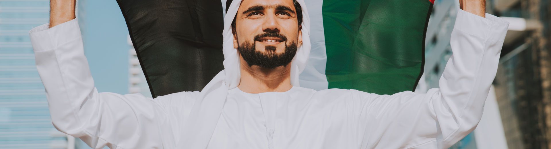 Man holding UAE flag in cityscape National Day UAE